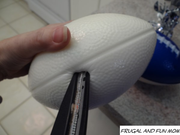 Pushing a hole into the foam football for the EASY DIY Football Party Centerpiece